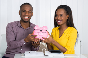 Happy Couple holding a piggy bank